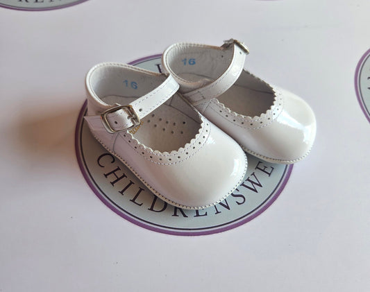Girls white patent leather mary jane pram buckle shoes on Amor Bambino childrenswear brand logo.